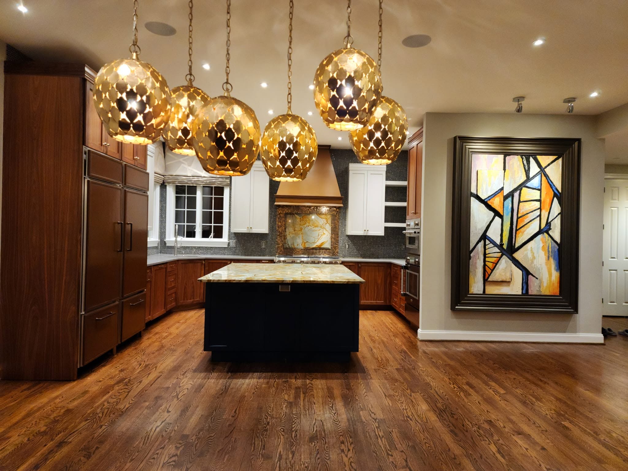 Completed residential kitchen cleaning by Rios Cleaning Services, with a stone island and hardwood floors